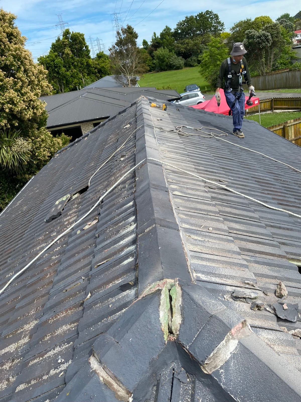 Apex Prime Roofing worker standing on a tile roof carrying out repairs