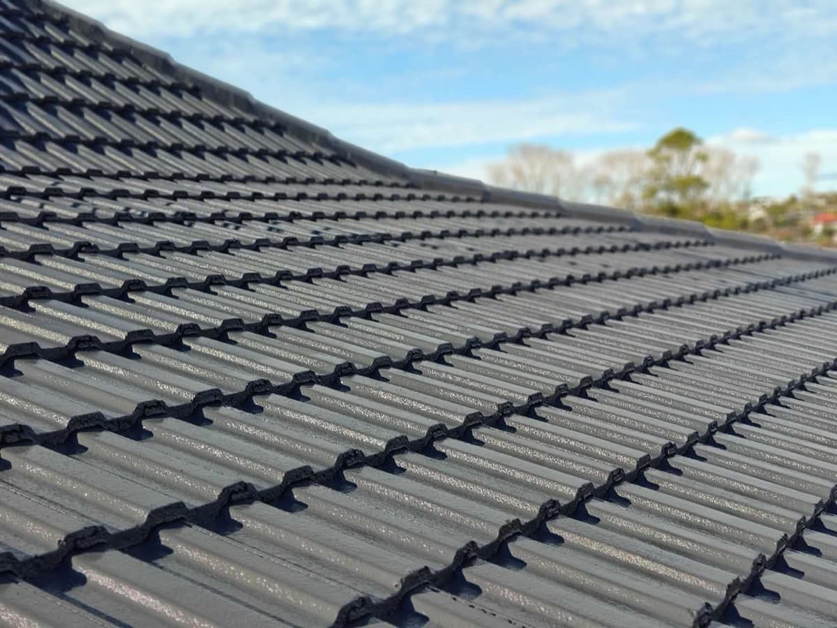 Close detail of evenly coated dark grey concrete tile profile in Auckland sunshine